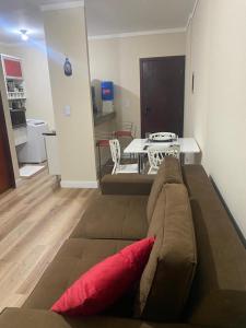 a couch with a red pillow in a living room at 1104 - Residence Service in Porto Velho