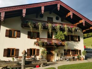 Un bâtiment avec un tas de plantes sur lui dans l'établissement Bojernhof, à Ruhpolding