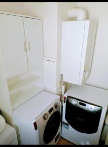 a small kitchen with a microwave and a refrigerator at Joli Duplex entièrement meublé in Chanteloup-les-Vignes