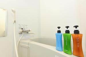 two water bottles sitting on a shelf in a bathroom at サンコート本郷通ガーデンヒルズ in Tsukisappu