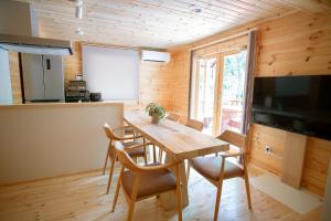 uma cozinha e sala de jantar com uma mesa de madeira e cadeiras em LEVATA em Nasu