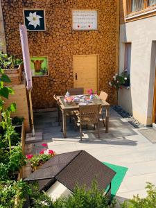 a patio with a table and chairs and a wall at Ferienwohnung4youallgaeu Terrasse, WLAN, Parkplatz, Spielezimmer, Grill u. Natur in Engetried 