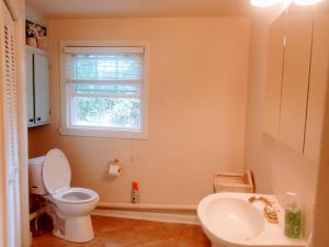a bathroom with a toilet and a sink and a window at University Heights Central 2 BRM in Athens