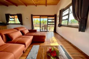 uma sala de estar com um sofá e uma mesa em Fare Te Ava - Comfy cabin w Private Beach Access em Haapiti
