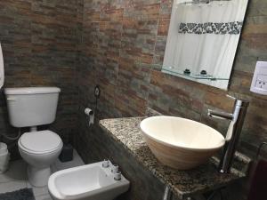 a bathroom with a white toilet and a sink at SALO&WALTHER in San Martín