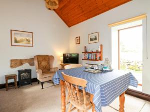 ein Wohnzimmer mit einem Tisch mit einem blauen und weißen Tischtuch in der Unterkunft Manifold Cottage in Grindon