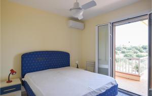 ein Schlafzimmer mit einem blauen Bett und einem Balkon in der Unterkunft Stunning Apartment In Marina Di Ragusa With Wi-fi in Marina di Ragusa