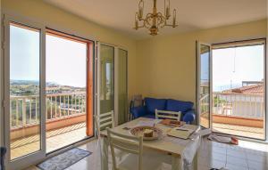 ein Wohnzimmer mit einem Tisch, Stühlen und Fenstern in der Unterkunft Stunning Apartment In Marina Di Ragusa With Wi-fi in Marina di Ragusa