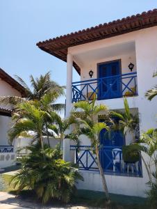 a white house with blue balconies and palm trees at Casa Solaris in Aquiraz +94 photos