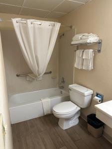 La salle de bains est pourvue de toilettes, d'une baignoire et d'un lavabo. dans l'établissement Big Bend Traveler's Inn, à Great Bend