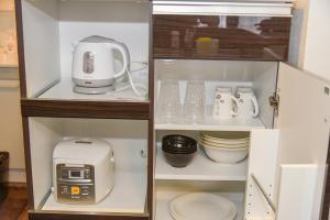 a cupboard with a blender and other appliances in it at サンコート円山ガーデンヒルズ in Ōdōri