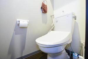 a white toilet in a bathroom with a roll of toilet paper at サンコート円山ガーデンヒルズ in Ōdōri