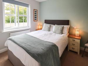 a bedroom with a large bed and two windows at Shore View in Grange Over Sands