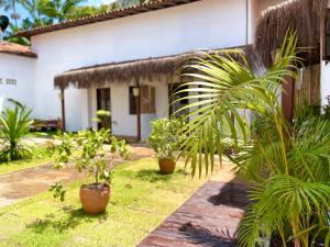 ein Haus mit Topfpflanzen davor in der Unterkunft VILA LITORANEA a in São Luís