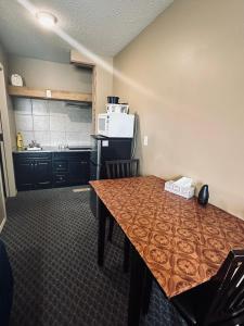 a kitchen with a table and a kitchen with a microwave at Voyageur Motel in Rocky Mountain House +15 photos