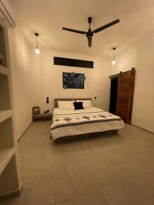 - une chambre avec un lit et un ventilateur de plafond dans l'établissement Hostel Flakos, à Zihuatanejo