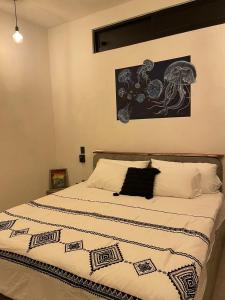 a bedroom with a bed with a black and white blanket at Hostel Flakos in Zihuatanejo