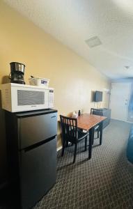 ein Hotelzimmer mit einem Tisch und einer Mikrowelle in der Unterkunft Voyageur Motel in Rocky Mountain House