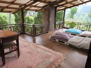 a bedroom with a bed and a table on a balcony at Aubrey Villa Ciwidey in Pengalongan