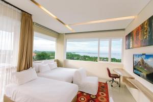a hotel room with two beds and a large window at Mahogany Hotel in Nusa Dua