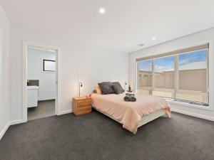 a bedroom with a bed and a large window at Rosella Retreat in Yarrawonga