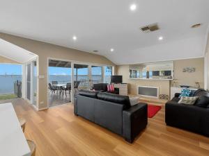 a living room with black furniture and a view of the ocean at Lakeside Mulwala in Mulwala