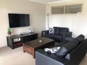 a living room with a black couch and a table at Cypress 39 A in Mulwala