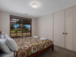 a bedroom with a bed and a large window at Lakeside Mulwala in Mulwala