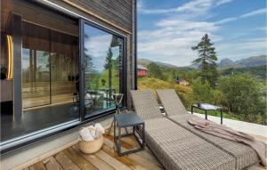 eine abgeschirmte Veranda mit 2 Stühlen und einem Tisch in der Unterkunft Amazing Home In Norheimsund With Wifi in Norheimsund