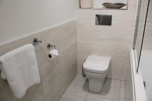 a bathroom with a toilet and a roll of toilet paper at The Peaks Three Bed Apartment in Aviemore