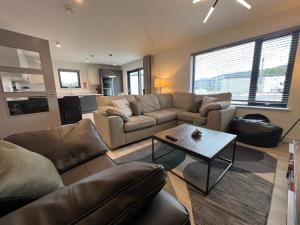 a living room with a couch and a table at The Peaks Three Bed Apartment in Aviemore
