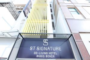 a sign for the st signature hotel in front of a building at ST Signature Bugis Beach in Singapore