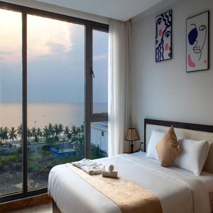 um quarto com uma cama e uma grande janela em KIKOZO DA NANG Hotel em Da Nang