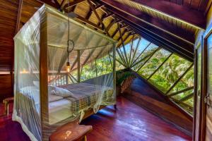a bedroom in a tree house with a canopy bed at Tree House Beachfront Lodge in Puerto Viejo