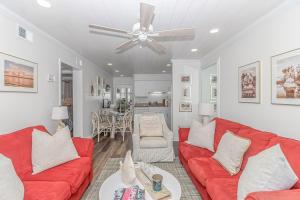 a living room with red couches and a ceiling fan at Cozy Condo, Beach Access, Dock, Pool, Sunsets in Myrtle Beach