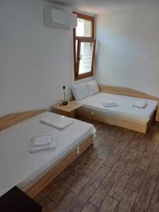 a room with two beds and a mirror at Guest House Lili in Petrich