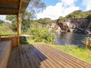 um deque de madeira com vista para um rio em Costentyn, Tor Down Quarry em Bodmin