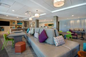 salon z kanapą i stołami w obiekcie Home2 Suites By Hilton Garden Grove w mieście Garden Grove