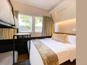 a hotel room with a bed and a window at ST Signature Bugis Beach in Singapore