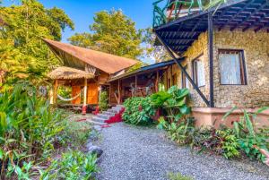 a house with a pathway in front of it at Tree House Beachfront Lodge in Puerto Viejo