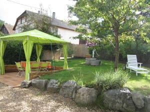 einen grünen Pavillon mit einem Tisch und Stühlen im Hof in der Unterkunft Gîte Bretten, 3 pièces, 6 personnes - FR-1-744-18 in Bretten