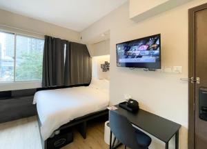 a hotel room with a bed and a flat screen tv at ST Signature Bugis Beach in Singapore