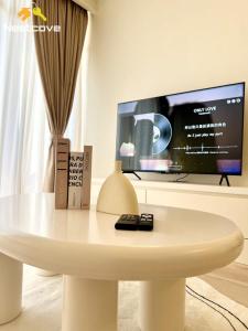 a white table with a tv in a room at Costa Mahkota Suites Malacca Central By Nestcove in Melaka