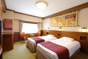 pokój hotelowy z 2 łóżkami i stołem w obiekcie Tokyo Bay Maihama Hotel First Resort w mieście Urayasu