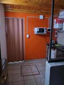 una cocina con una pared de color naranja y una puerta en Monoambiente excelente ubicación no mascotas en Mendoza