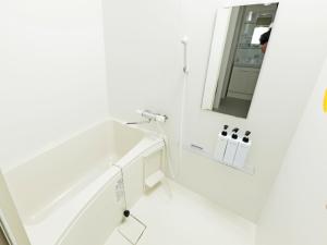 a white bathroom with a sink and a mirror at APHONGO HOTEL in Tsukisappu