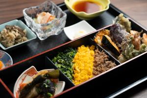 a tray filled with different types of food on a table at Sunrise Hotel Okinawa-どこか懐かしいレトロ宿軽朝食付 in Okinawa City