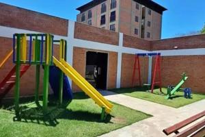 a playground with a slide in front of a building at Fantastico en Luque con Cochera Zona Aeropuerto in Luque