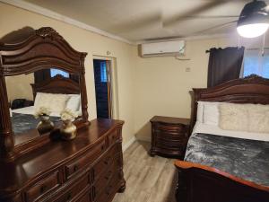 a bedroom with two beds and a large mirror at 11onEssex1 in the heart of Kingston Ja DN Vacations in Kingston