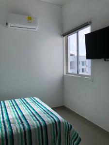 a white room with a bed and a window at Hermoso Apartamento en Caribe Campestre in Coveñas